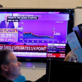 Un operador de la Bolsa de Nueva York (NYSE, en sus siglas en inglés) observa en un monitor el anuncio de la última bajada de tipos de la Reserva Federal de EEUU. REUTERS / Brendan McDermid