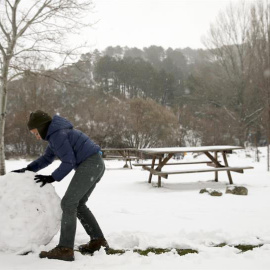 Un niño juega con la nieve en un área recreativa próxima a la localidad de Robledondo, en la sierra norte de Madrid. / BALLESTEROS (EFE)