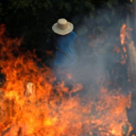 Un hombre trabaja en un tramo de la Amazonia en llamas. / Reuters