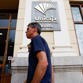 Un hombre pasa por delante de unas oficinas de Unicaja en Ronda (Málaga). REUTERS/Jon Nazca