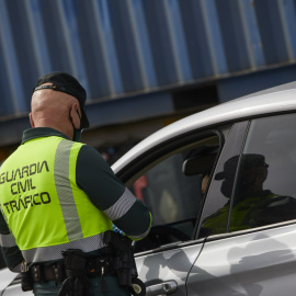 26/03/2021. Imagen de archivo de un agente de la Guardia Civil de Tráfico pidiendo la documentación durante un control en la carretera R5 km 20, en Madrid. - EUROPA PRESS