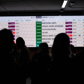 Imagen de archivo de varias personas observando la pantalla de horarios de los trenes en una estación de Madrid.