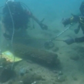 Membres de l'Armada manipulen la bomba de la platja de la Barceloneta moments abans de fer-la explotar. Guàrdia Civil