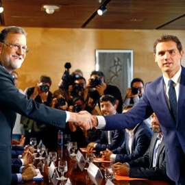 El presidente del Gobierno y del PP, Mariano Rajoy (d) y el de Ciudadanos (i), junto a sus equipos negociadores del pacto de investidura. Archivo EFE.