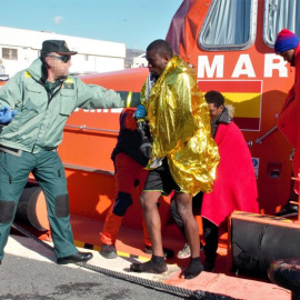 Un agente de la Guardia Civil ayudando a los 36 inmigrantes de origen subsahariano que viajaban en una patera y que han sido rescatados a 11 millas de la isla de Alborán por Salvamento Marítimo. EFE/Alba Feixas