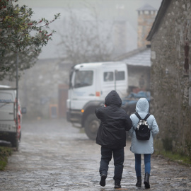 Dos personas pasean abrigadas por una calle de Pedrafita do Cebreiro, en Lugo, a 13 de diciembre de 2023.