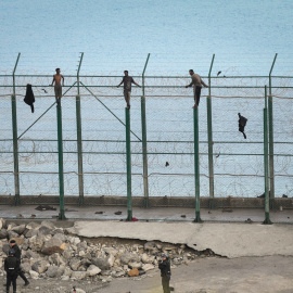 30/08/2019 - En la imagen, tres de un total de 153 migrantes, entran en Ceuta saltando su doble valla en la primera incursión en grupo en un año / EUROPA PRESS