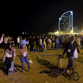 15/05/2021. Varios jóvenes recogen sus pertenencias en la playa de la Barceloneta mientras la Policía desaloja la zona, este sábado en Barcelona. - EFE