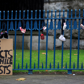 Una niña cuelga un zapato de bebé en una valla para protestar contra los abusos de la Iglesia- REUTERS/Gonzalo Fuentes