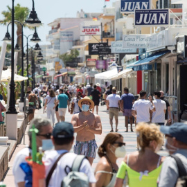 Varias personas disfrutan del buen tiempo paseando por el paseo marítimo de la playa de La Carihuela de Torremolinos, este sábado.