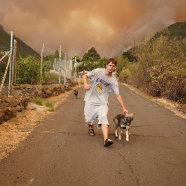 16/8/23 Vecinos de Los Margenes, en el pueblo de Igueste de Candelaria, evacuan enseres y animales ante el avance del fuego. En la imagen, un joven saca a sus perros de su casa.