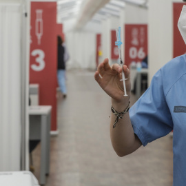 Una profesional sanitaria sostiene una jeringuilla con la vacuna de AstraZeneca, en el Hospital la Fe, en València.