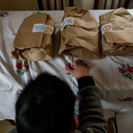 Un niño durante la comida en su casa del barrio madrileño de Carabanchel momentos antes de abrir el menú de la ONG del chef José Andrés, que reparte en Madrid a las familias más necesitadas durante el estado de alarma provocado por el coron