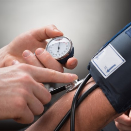 Médico midiendo la presión arterial a un paciente. ISTOCK