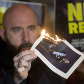 El concejal de la CUP en el Ayuntamiento de Barcelona Josep Garganté quema una foto del Rey./ EFE