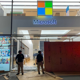 Los miembros de seguridad montan guardia frente a la Microsoft Store destruida en la quinta avenida