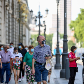 Varias personas pasean con mascarilla durante el último día de la obligatoriedad de mascarillas en exteriores, este viernes en Madrid. - EUROPA PRESS