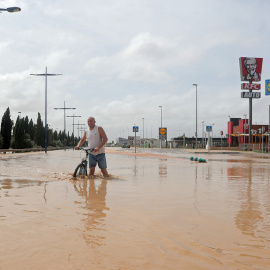 Un hombre camina por una calle inundada tras de fuertes lluvias por la gota fría en San Javier, Murcia.- REUTERS / SERGIO PÉREZ