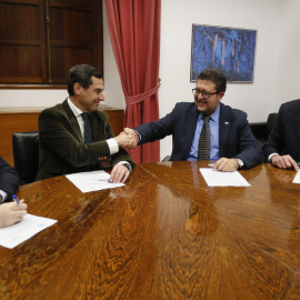 Los líderes andaluces del PP, Juan Manuel Moreno Bonilla, y de Vox, Francisco Serrano, estrechan las manos en presencia de los secretarios generales del PP, Teodoro García Egea, y de Vox, Francisco Javier Ortega Smith, durante la reunión en