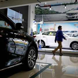 Un hombre camina en un concesionario de automóviles eléctricos en Shanghai. REUTERS / Aly Song