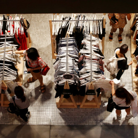 Un grupo de mujeres echan un vistazo a varios conjuntos de ropa en una tienda de un centro comercial de Sidney. REUTERS/Daniel Munoz