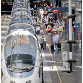 Estación con tren AVE y viajeros de Renfe. E.P.