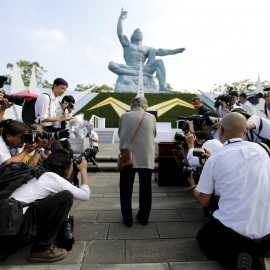 Los fotógrafos rodean a una anciana que reza delante del monumento a las víctimas de Nagasaki, frente al Momumento a la Paz, en la ciudad japonesa, que celebra el 70 aniversario de la biomba atómica. REUTERS/Toru Hanai