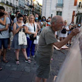 Varias personas observan trabajar al pintor  Antonio Lopez en la céntrica Puerta del Sol de  Madrid. REUTERS/Juan Medina