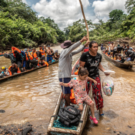 Una migrante venezolana baja junto a su hija de una canoa tras cruzar la selva del Darién, que separa Colombia de Panamá, en su ruta migratoria hacia EEUU.