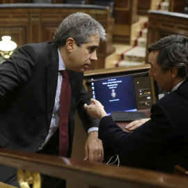 El portavoz de Democràcia i Llibertat (DiL), Francesc Homs (i), conversa con el portavoz del PP, Rafael Hernando (d), durante la sesión de la tarde de la segunda jornada del debate de investidura del secretario general del PSOE, Pedro Sánch