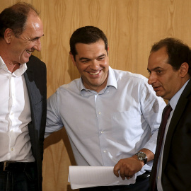 El primer ministro griego, Alexis Tsipras, con el ministro de Economía,  Giorgos Stathakis, y el de Infraestructuras, Christos Spirtzis, tras un acto  en Atenas, el primero tras el acuerdo entre el Ejecutivo heleno y la troika para el terce