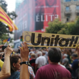 Un manifestant aixeca un cartell on posa "unitat!" repartit per membres de la Crida per la República durant la manifestació del segon aniversari dels escorcolls a la seu del Departament d'Economia. Ander Zurimendi