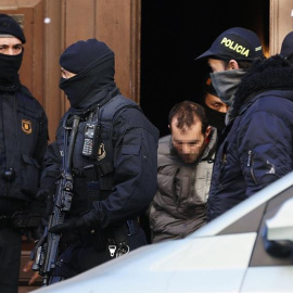 15/01/2019.- Los Mossos d,Esquadra trasladan a uno de los detenidos en el distrito de el Clot de Barcelona, tras efectuar desde primera hora de la mañana una operación antiterrorista contra una célula yihadista en Barcelona e Igualada. EFE/