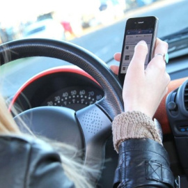 Una mujer usa el móvil al volante