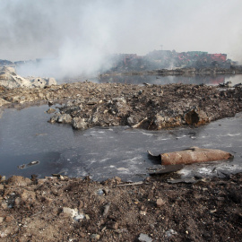 Pequeño lago de un líquido indeterminado en la zona, todavía humeante, de las explosiones producidas el pasado miércoles en Tianjin. - REUTERS