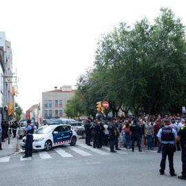 Mossos d'Esquadra controlan a la multitud que se ha congregado ante el domicilio en el que agentes de la Guardia Civil llevan a cabo un registro en Sabadell (Barcelona). /EFE