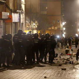 Policías antidisturbios en la calle Mesón de Paredes con la calle del Oso, en el barrio de Lavapiés de Madrid, repelen las protestas tras la muerte de un mantero de un paro cardíaco durante un control policial. | JAVIER LIZÓN (EFE)