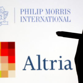 Unos dedos sujetan un cigarrillo en una composición con los logos de Altria y de Philip Morris. REUTERS