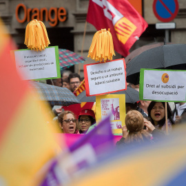 Varias personas muestra pancartas en la manifestación celebrada hoy por el centro de Barcelona bajo el lema: "¡Ahora nos toca a nosotros! + igualdad, + empleo + salarios + pensiones", en favor de unas pensiones y salarios dignos en la tradi