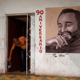 Un hombre en la puerta de su vivienda en La Habana, en cuya fachada tiene pintado un retrato de Fidel Castro. REUTERS/Stringer