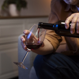 Hombre se sirve vino en una foto de archivo.