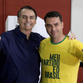 Jair Bolsonaro, y su hijo, Flávio, tras depositar su voto en las elecciones, Río de Janeiro, Brasil, 7 de octubre de 2018. / Ricardo Moraes / Reuters