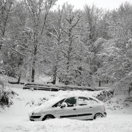 Un coche permanece atascado en la nieve en el Alto de Mezquiriz donde, tras el último temporal de nieve, frío y viento. /EFE