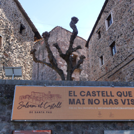 El marcador electrònic amb el castell de Santa Pau al fons