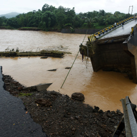 Locals look into a damaged bridge after floods hit Manuju in Gowa, South Sulawesi, Indonesia, January 23, 2019 in this photo taken by Antara Foto. Picture taken January 23, 2019. Antara Foto/Yusran Uccang/ via REUTERS ATTENTION EDITORS - TH