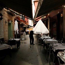 Un camarero abre una sombrilla en una terraza de un bar en Sevilla. REUTERS