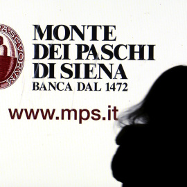 Una mujer pasa por delante de un anuncio del banco Monte dei Paschi di Siena en el centro de Milán. REUTERS/Stefano Rellandini