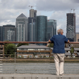 Un hombre mira hacia el distrito financiero de Canary Wharf en Londres. REUTERS/Simon Dawson