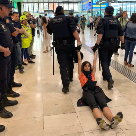 Dos mossos arrosseguen una activista dels CDR que formava part del bloqueig a l'Estació de Sants aquest diumenge al matí. Marià de Delàs