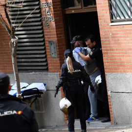 Agentes de la Policía Nacional reducen y sacan de la vivienda al hombre que se había atrincherado con una mujer este lunes en un piso en Leganés (Madrid). /EFE